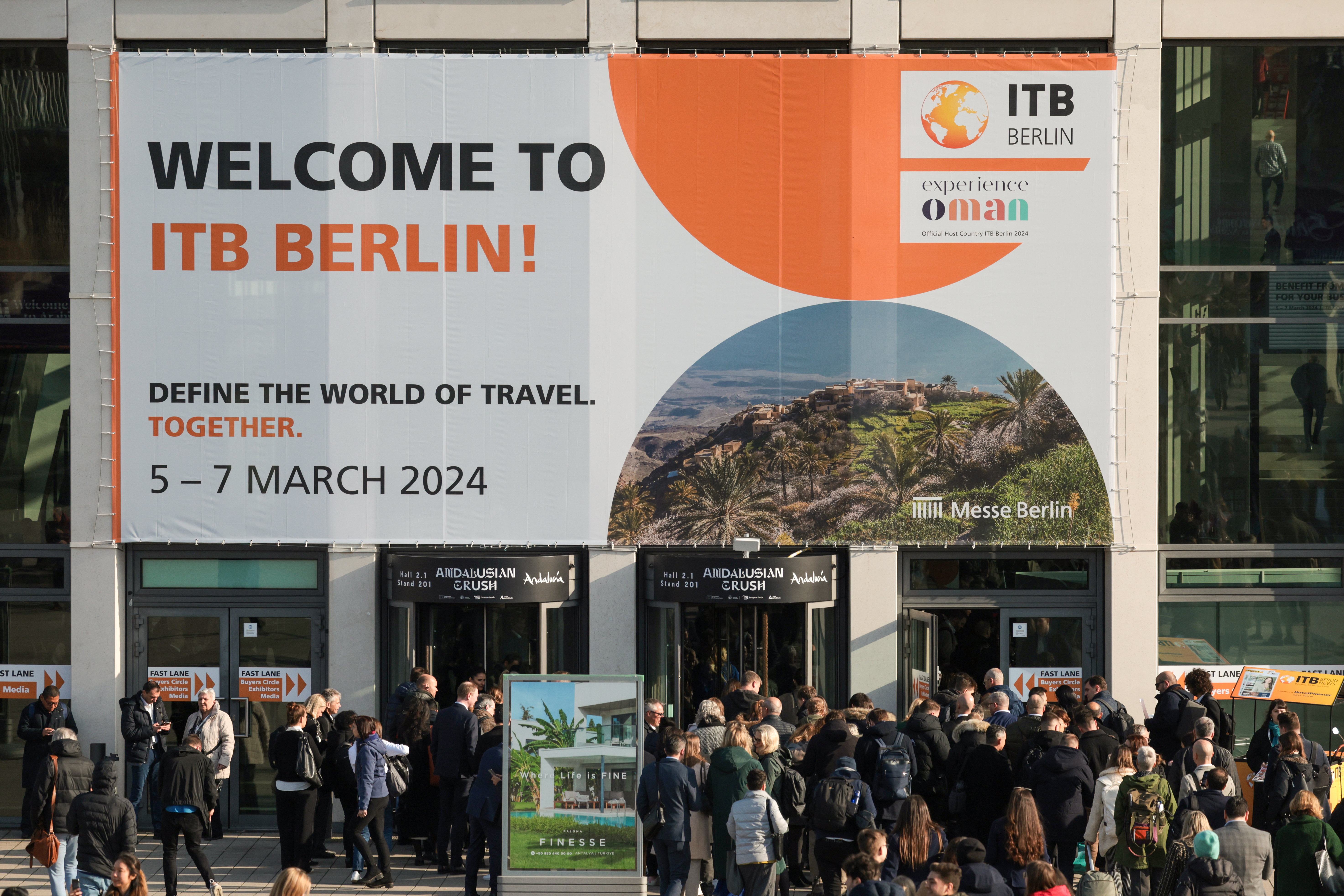 Menschen auf dem Weg zum Eingang Süd im Vordergrund, ein Banner mit der Aufschrift Welcome to Berlin im Hintergrund