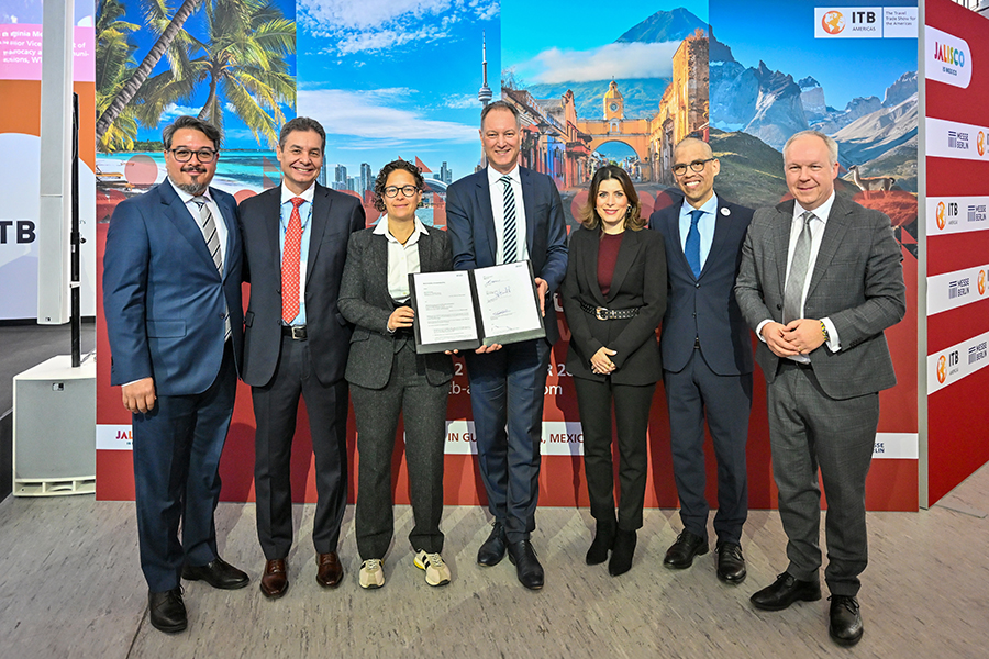 Das Bild zeigt eine Gruppe von sieben Personen, die in einer Reihe stehen und sich für ein Foto präsentieren