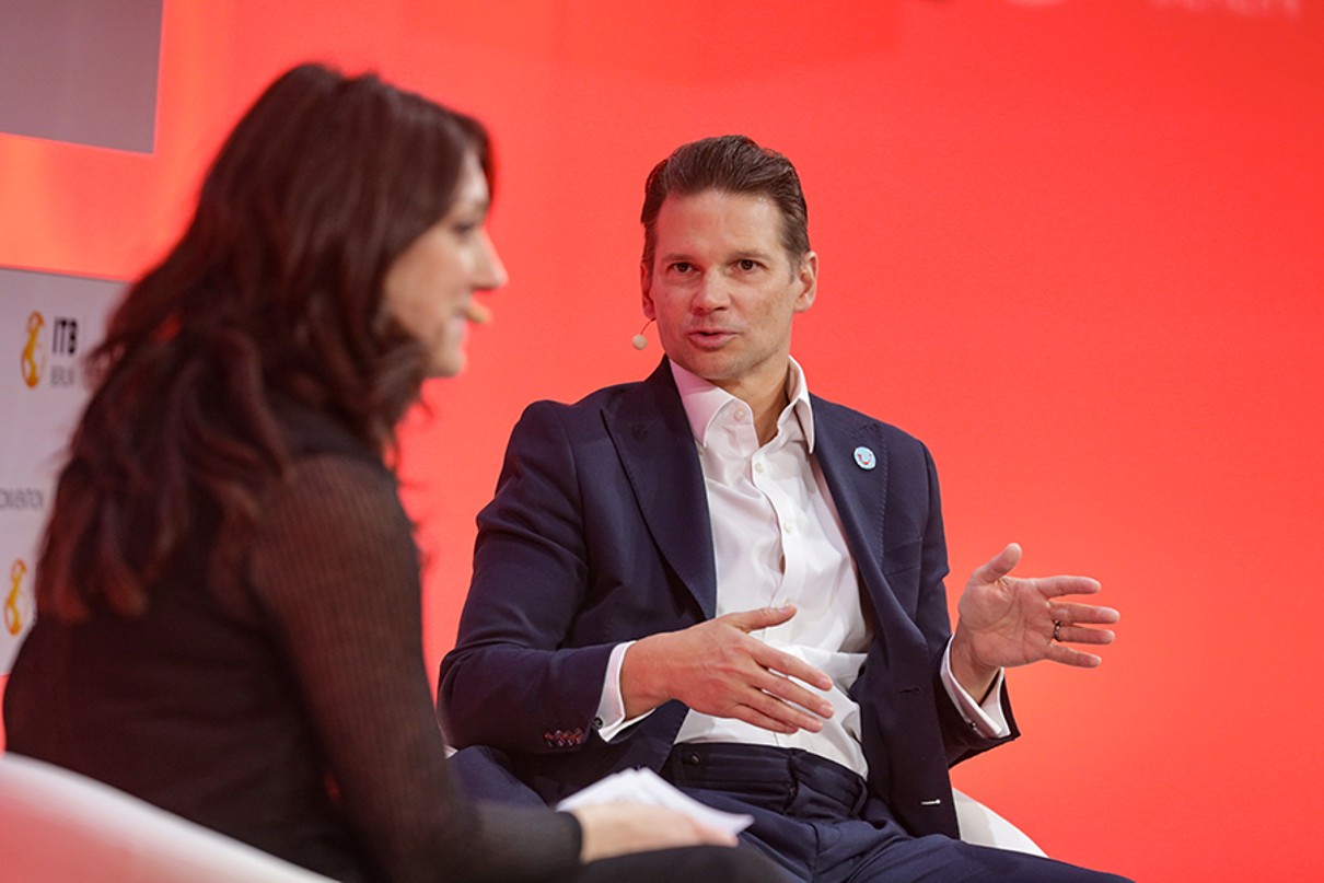 Two people sit on the stage and discuss