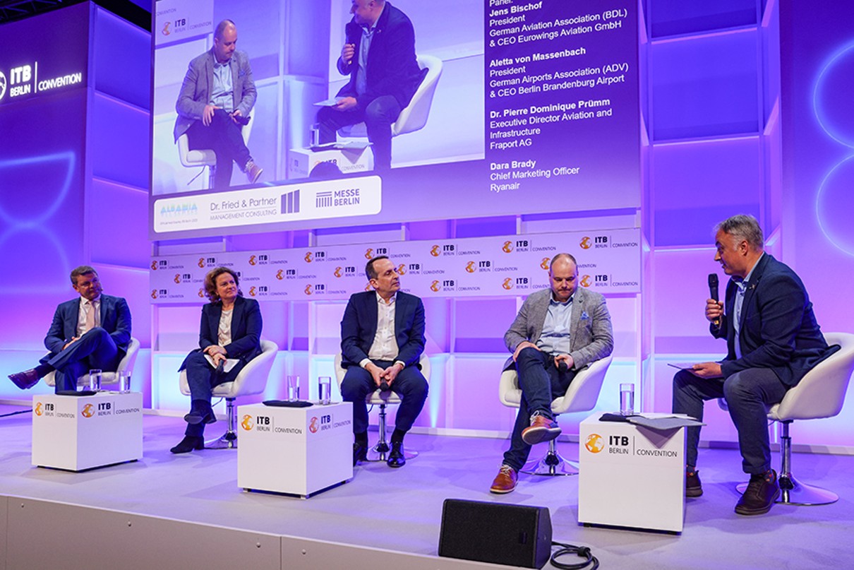 The participants are in discussion while seated onstage