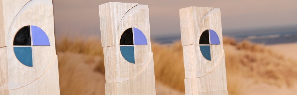 Drei TO DO Awards aus Holz vor einem Strandhintergrund. 