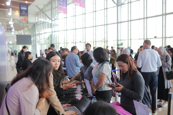 Delegates gather at the registration counter during Travel Meet Asia, engaging with staff and checking in for the event in a bright, modern venue.