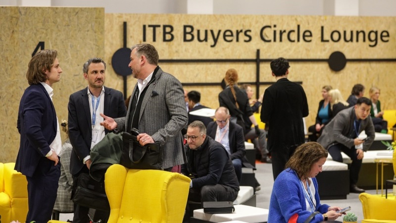 Groups of people in a room, with „ITB Buyers Circle Lounge“ on the wall in the background. 