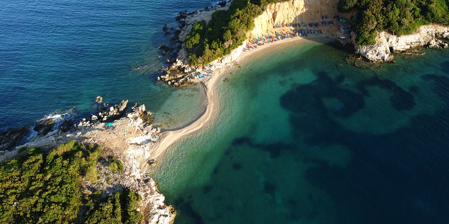 A bird's eye view of a bay with sun loungers and turquoise sea. A bird's eye view of a bay with sun loungers and turquoise sea.
